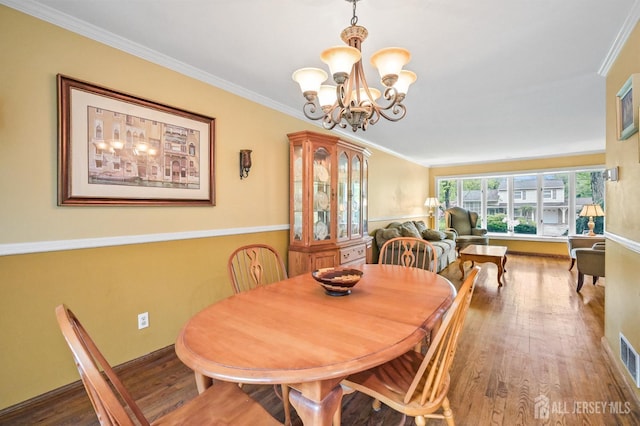 134 Devon Rd, Colonia, NJ 07067 - dining room featuring wood finished floors, a chandelier, and crown molding