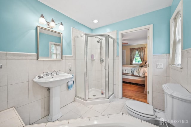 134 Devon Rd, Colonia, NJ 07067 - ensuite bathroom featuring tile walls, tile patterned flooring, a stall shower, and a wainscoted wall