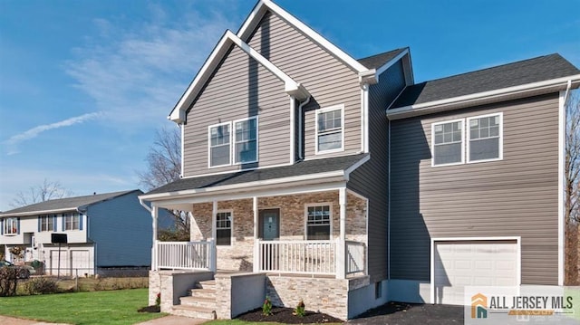 view of front of house featuring a front yard, covered porch, and an attached garage