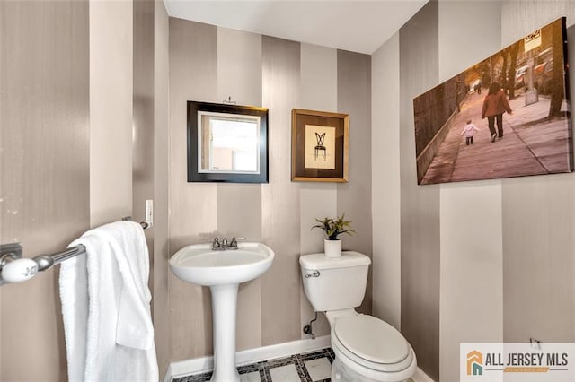 bathroom with toilet and baseboards
