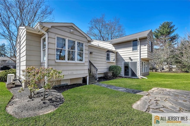 rear view of property featuring a lawn
