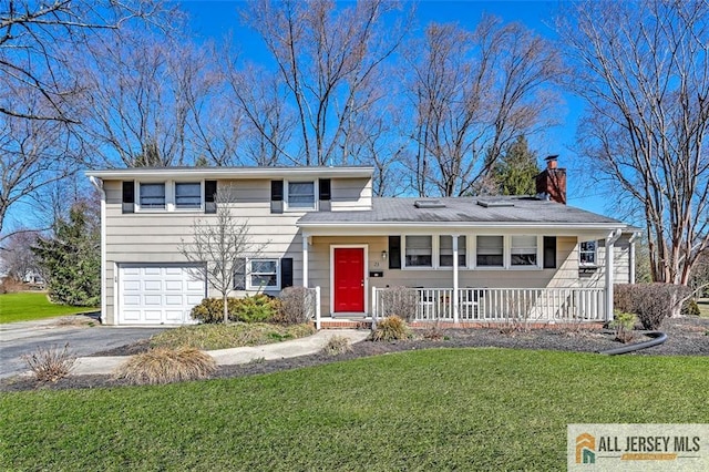 split level home with a front lawn, driveway, a porch, a garage, and a chimney