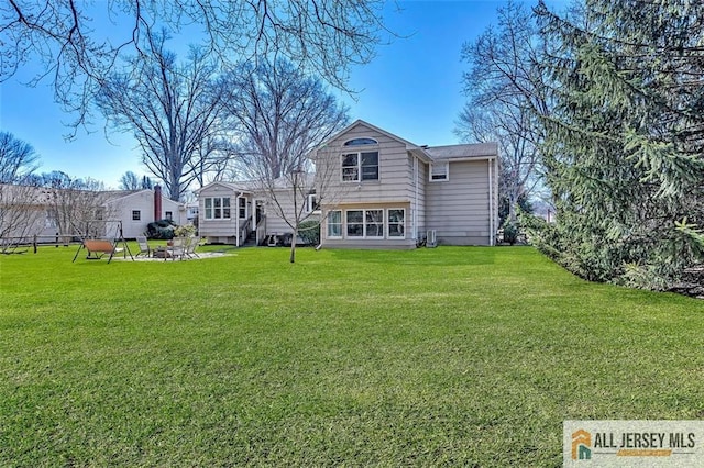 rear view of property featuring a yard