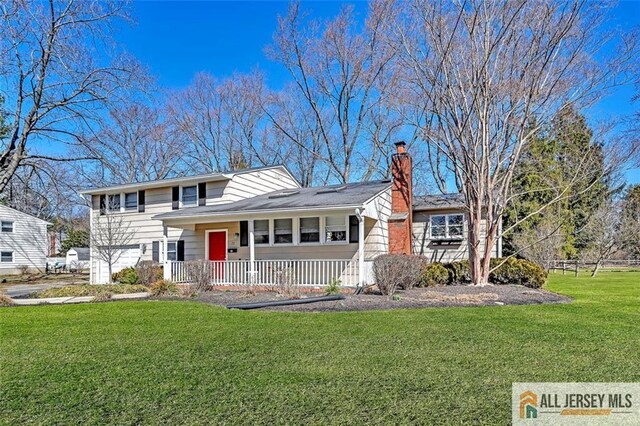 split level home with a front yard, a porch, and a chimney