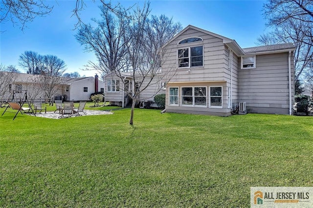 back of house featuring central AC unit, a patio, and a lawn