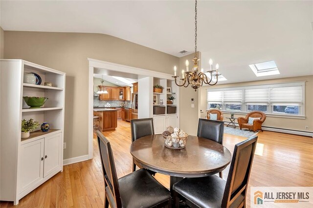 dining space featuring a chandelier, light wood finished floors, visible vents, and lofted ceiling with skylight