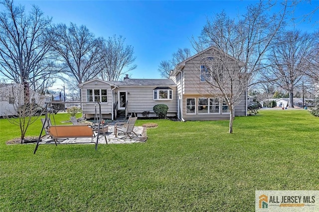 rear view of property featuring a patio, entry steps, and a yard
