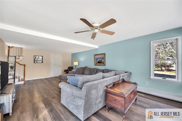 living room with baseboards, a ceiling fan, dark wood finished floors, baseboard heating, and stairs