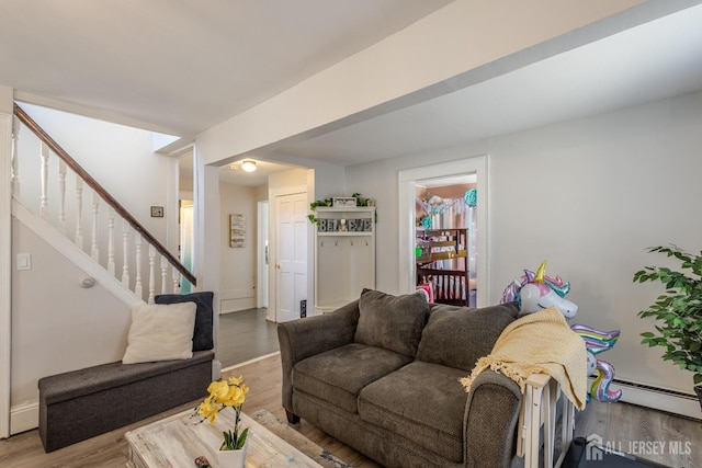 living room with a baseboard radiator, stairs, and wood finished floors