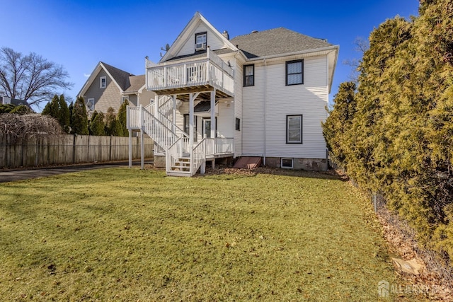 back of house with stairs, a deck, a lawn, and fence