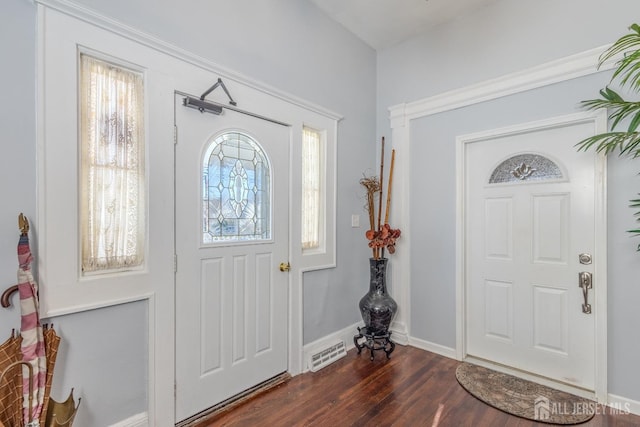 foyer featuring visible vents, dark wood-type flooring, and baseboards