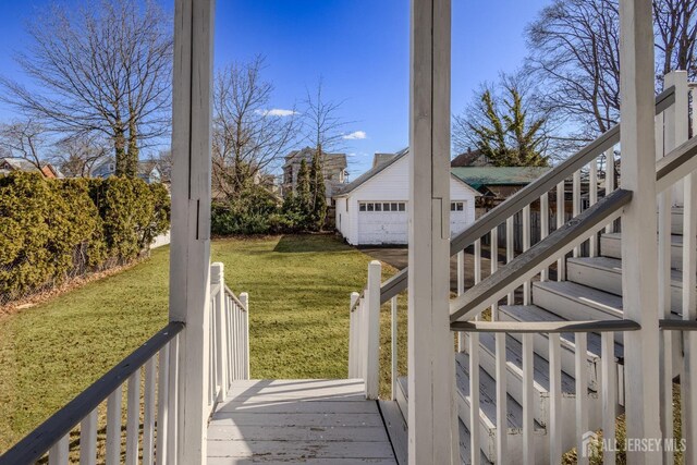 wooden deck with an outbuilding, stairway, and a yard
