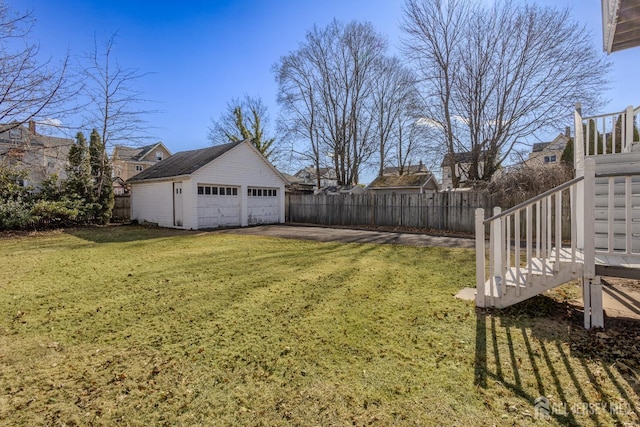view of yard featuring stairs, an outbuilding, fence, and a detached garage