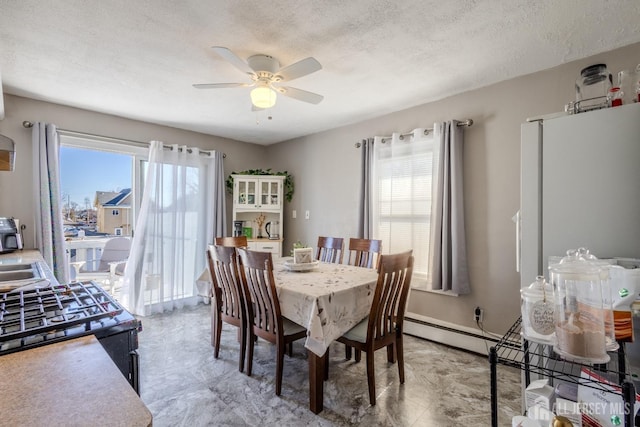 dining room featuring baseboards, a healthy amount of sunlight, a textured ceiling, and ceiling fan