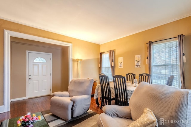living area with baseboards, wood finished floors, and ornamental molding