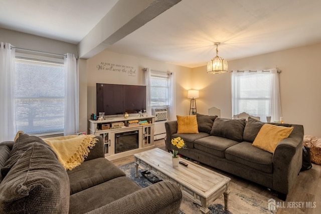 living area featuring a baseboard radiator, an inviting chandelier, and wood finished floors