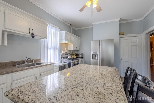 kitchen featuring a sink, under cabinet range hood, stainless steel appliances, white cabinets, and crown molding
