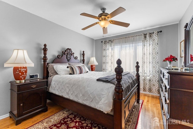 bedroom featuring wood finished floors, a ceiling fan, and baseboards