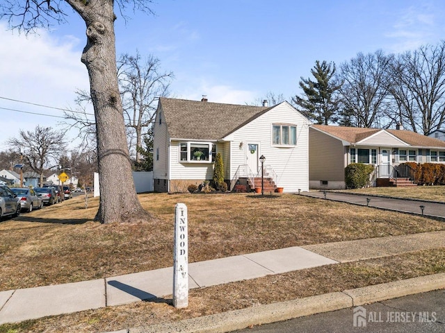 view of front of home with a front lawn and roof with shingles