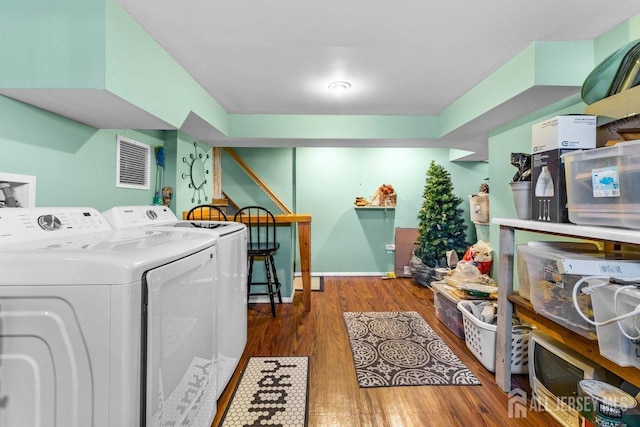 clothes washing area with washer hookup, wood finished floors, and visible vents