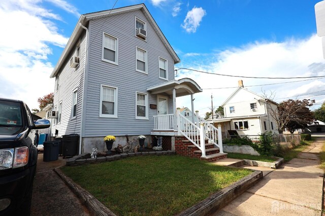 view of front facade with cooling unit and a front yard