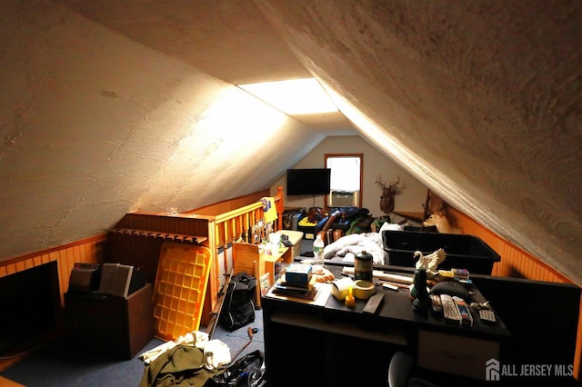 bonus room with lofted ceiling and wooden walls