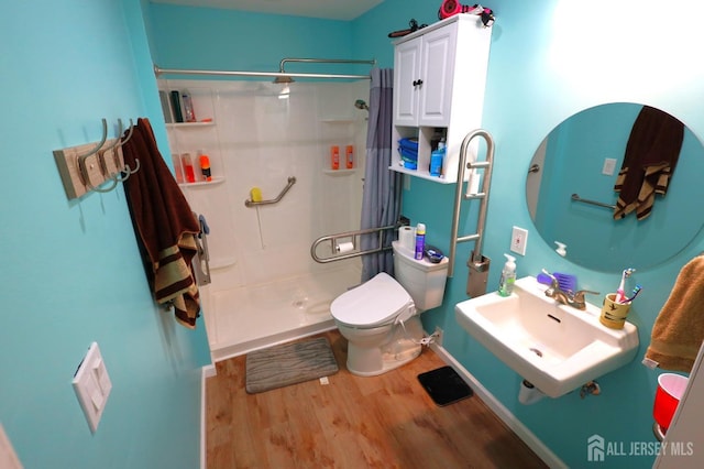 bathroom featuring walk in shower, toilet, sink, and hardwood / wood-style floors