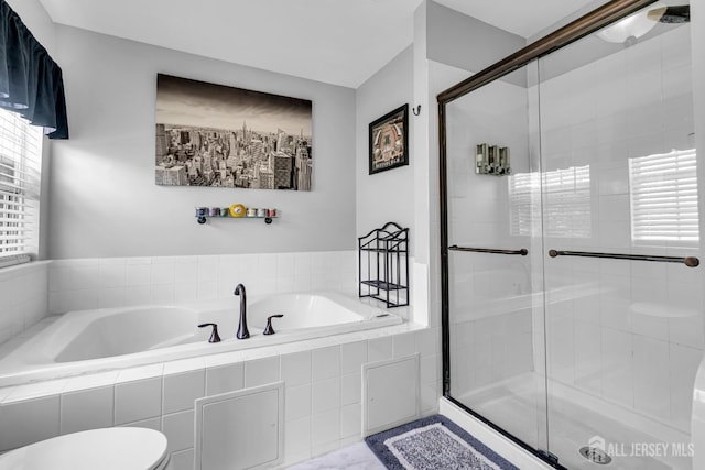 full bath featuring a garden tub, a shower stall, and toilet