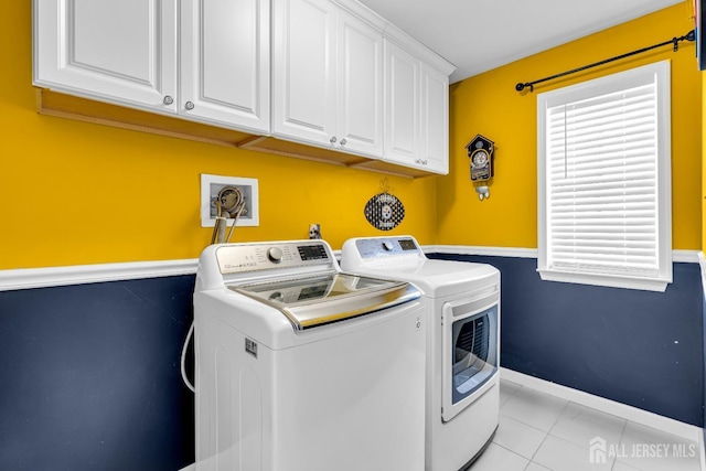 laundry area featuring washer and dryer, cabinet space, and baseboards