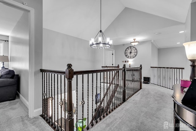 hall featuring carpet floors, an upstairs landing, lofted ceiling, a chandelier, and baseboards
