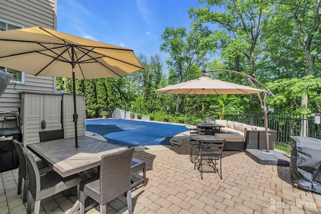 view of pool with outdoor dining space, a fenced backyard, an outdoor living space, and a patio