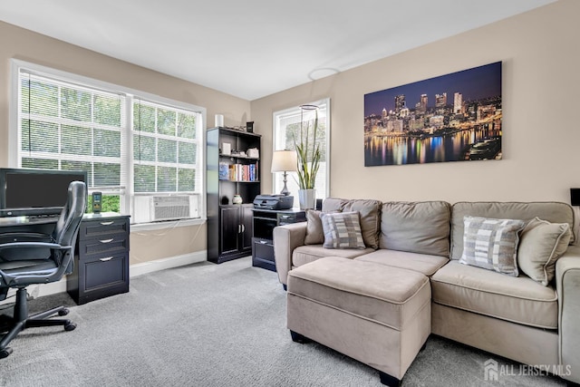 living room with a desk, baseboards, light carpet, and cooling unit