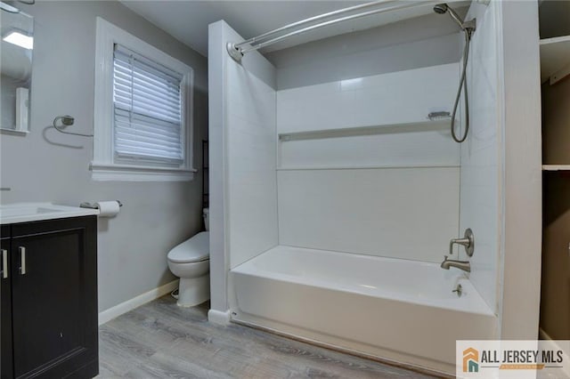 full bathroom featuring hardwood / wood-style floors, vanity, toilet, and  shower combination