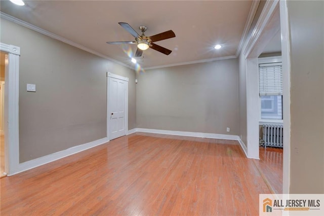 spare room featuring ornamental molding, radiator, ceiling fan, and light hardwood / wood-style floors