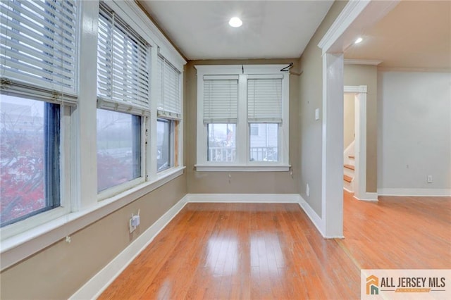 spare room featuring ornamental molding and light wood-type flooring