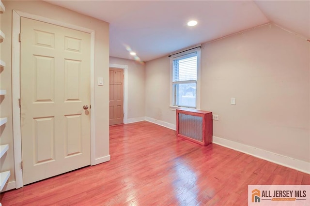 unfurnished room featuring hardwood / wood-style flooring and lofted ceiling