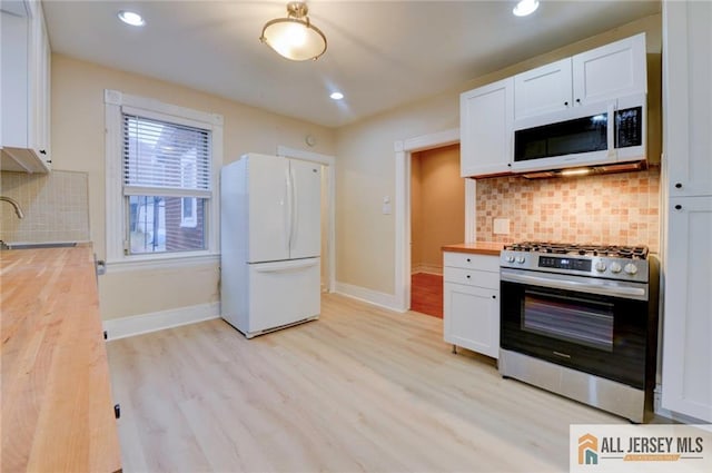 kitchen with white cabinetry, sink, white appliances, and wood counters