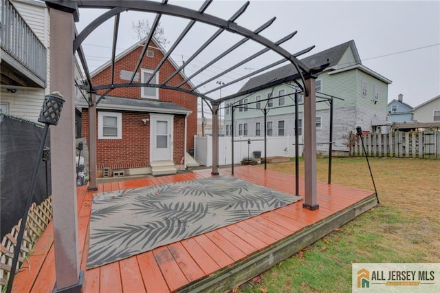 wooden terrace featuring a yard and a pergola