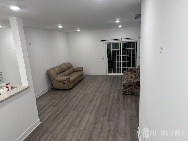 unfurnished room with dark wood-type flooring, baseboards, and visible vents