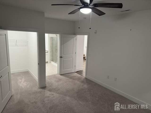 unfurnished bedroom with a spacious closet, visible vents, baseboards, carpet floors, and a closet