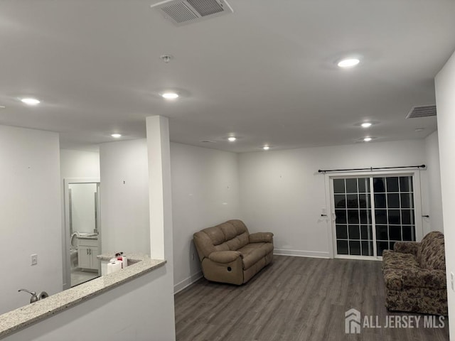 living area featuring visible vents, recessed lighting, baseboards, and wood finished floors