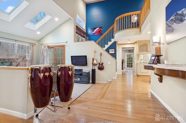 interior space with high vaulted ceiling, light wood-type flooring, baseboards, and recessed lighting