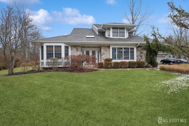 view of front facade featuring stone siding, a front lawn, and a shingled roof