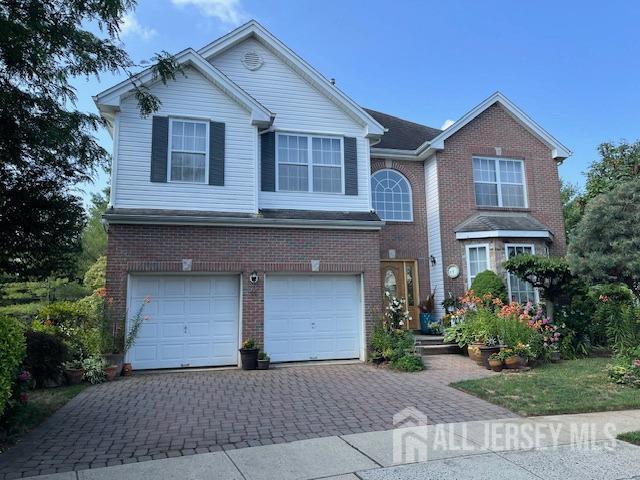 11 Pebble Beach Ct, Monroe, NJ 08831 - traditional home featuring a garage, decorative driveway, and brick siding