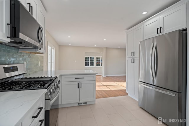 kitchen with visible vents, white cabinets, a peninsula, and stainless steel appliances