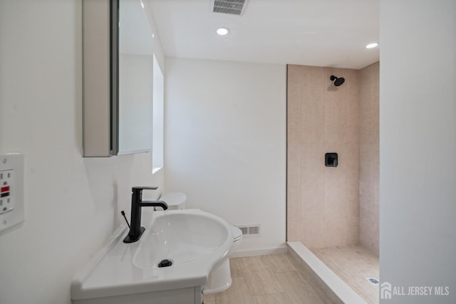 full bathroom featuring recessed lighting, visible vents, baseboards, and a tile shower