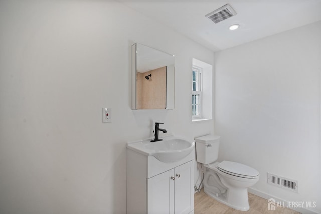 bathroom with visible vents, toilet, and vanity