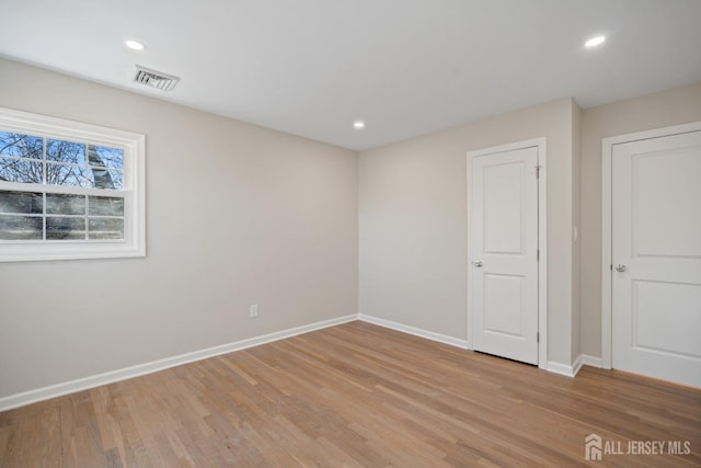 unfurnished room featuring visible vents, recessed lighting, light wood-type flooring, and baseboards