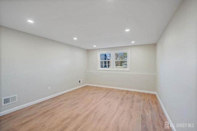 empty room with recessed lighting, visible vents, baseboards, and wood finished floors