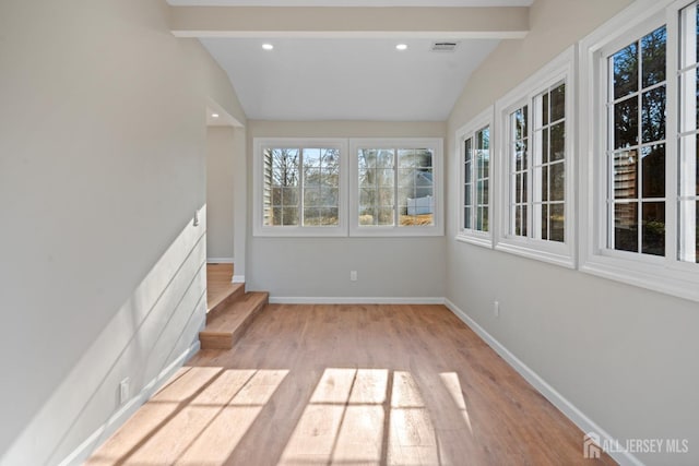 unfurnished sunroom featuring visible vents and vaulted ceiling with beams